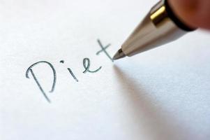 Close up image of writing a word DIET on a notebook paper. photo