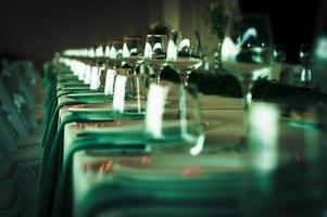 Wedding table in green tone with shiny tableware. photo