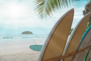 Many surfboards for rent  at summer beach with sunlight  blue sky. photo