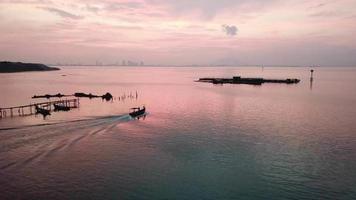 una barca che lascia il molo di pesca a jelutong, penang, malesia. video