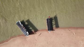 barco de pesca con vista de arriba hacia abajo con sombra cerca de la costa. video