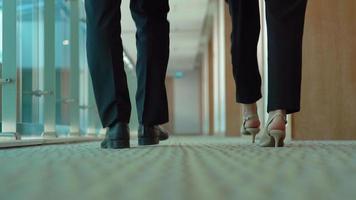 empresario y empresaria caminando en el pasillo. pies de hombre de negocios y empresaria caminando en el pasillo. video