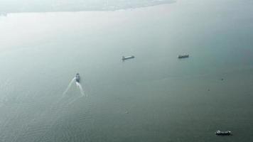 vista aérea balsa velejar no mar com navio ao redor no estreito de malaca. video