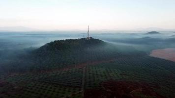 Luftaufnahme Rotationsaufnahme Fernmeldeturm auf der Spitze eines Hügels. video