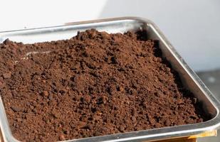 Coffee grounds in a stainless-steel drying under the sunlight. Recycle concept photo