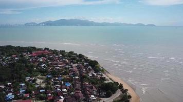 volar sobre el pueblo de kuala muda con el mar de fondo y la isla de penang. video