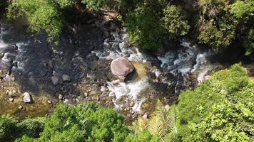 Aerial look down natural water flow over rock in rainforest video