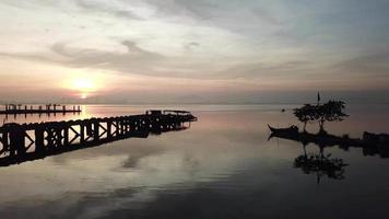 barco de pesca se move em direção ao mar durante o nascer do sol em jelutong, penang, malásia. video