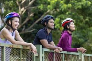 Team of Asian cycling friends taking a rest and enjoy looking at the view in public park photo