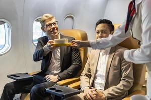 Flight attendant is serving food to the customer for in flight meal, airline travel and transportation concept photo