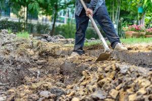 el jardinero cava el suelo con su equipo para jardinería y prepara la tierra para la plantación. foto