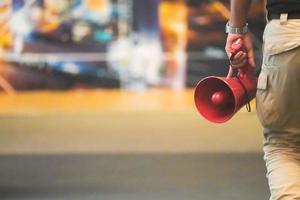 Red Megaphone in man hand with blur backround. photo