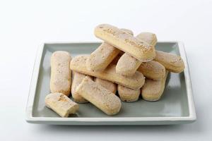 Close up view of Ladyfinger Fiscuit Cookie in Plate on White Background. Italian Cookie Savoiardi. photo