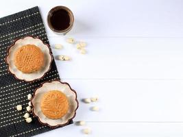 Mooncake on White Background with Tea. Concept Moon Cake on Mid Autumn Festival or Chinese New Year. Mooncake Popular as Kue Bulan. Served with Chinese Tea photo