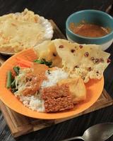 Nasi Pecel, Indonesian Traditional Menu with Spicy Peanut SAuce, Tempeh, Boiled Vegetable, and Fried Tofu, Rempeyek, Popular for Breakfast, Dinner, or Lunch photo