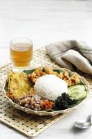 Nasi Campur Cumi Asin Surabaya, White Rice with Sautee Salted Squid, Sambal, Egg, and Boiled Cassava Leaf. photo