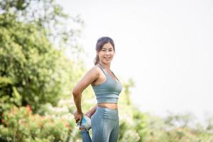deportista calentándose al aire libre, mujer fitness con ropa deportiva entrenamiento de calentamiento hacer ejercicio de estiramiento al aire libre foto