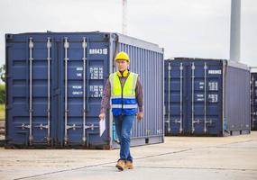 Foreman dock worker in hardhat and safety vest control loading containers box from cargo, Engineer with clipboard checklist in industry containers cargo photo