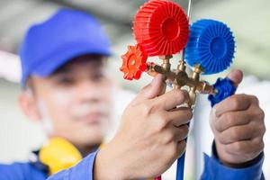 Repairman holding monitor tool to check and fixed car air conditioner system, Technician check car air conditioning system refrigerant recharge, Air Conditioning Repair photo