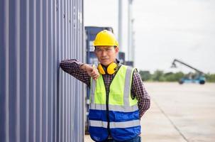 Relaxing engineer man in industry containers cargo, Foreman dock worker in hardhat and safety vest control loading containers box from cargo photo