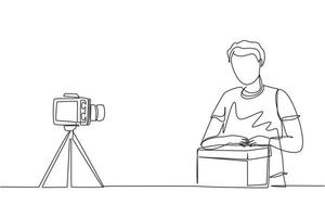 Single continuous line drawing male vlogger unbox and review product live on youtube in studio. Social media influencer recording unboxing video at home. One line draw design vector illustration