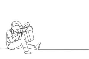 Single one line drawing cheerful boy sitting and hugging big gift box with ribbon bow wrapped in front of his in arms. Little kid accept birthday gift. Continuous line draw design vector illustration