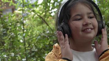 menina ouve música com fones de ouvido sem fio video