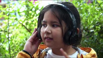 liten flicka lyssnar på musik med trådlösa hörlurar video