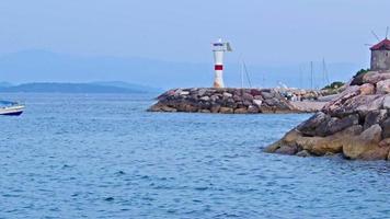 Pequeña embarcación recreativa que regresa al puerto del pueblo de pescadores video