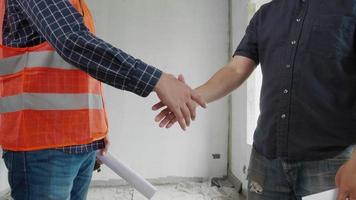 stretta di mano dell'ingegnere con il proprietario del cantiere nel cantiere. video