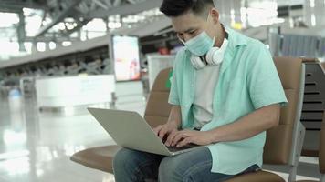 Man using laptop and wearing protective mask.