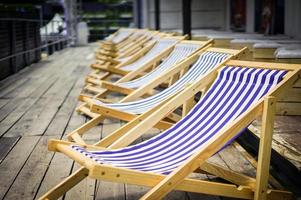 Navy line on canvas chairs with old wood terrace. photo