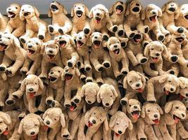 Brown dog dolls hang on to the wall for sales in kid depart at departmentstore. photo