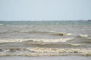 close up dirty brown wave from the sea to the beach. photo