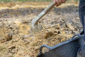 el jardinero cava el suelo con su equipo para jardinería y prepara la tierra para la plantación. foto