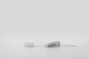 Isolated simple and normal white toothbrush with small toothpaste on the white background in studio light. photo