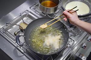 Fried salmon piece in the oil pan. photo