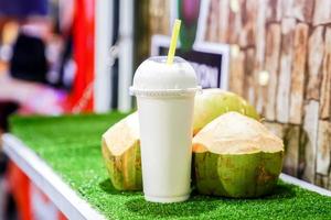 coconut mixed with milk ready for drink, stand by at the front of the real coconut. photo