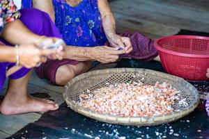 Fisherman female are preparing the dried shrimp for sales. photo
