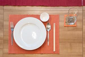 japanese modern applied dining room style with eastern dish, fork, spoon, napkin and glass on the table. photo