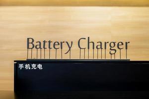 Battery Charger Art Letter pop-up sign on the black counter with Chinese Language. Chinese Laguage in picture mean battery charger. photo