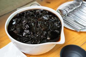 Thailand black grass jelly eat in big white bowl and ice inside it for dessert in the hot summer season. photo