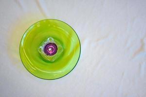 Topview of the Candle in square glass on green dish with white cloth background. photo