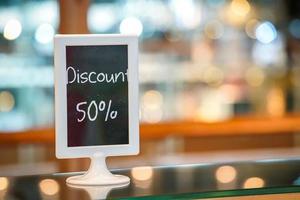 discount 50 percent on the black board standy in the bakery shop. Beautiful Blurry and bokeh background photo