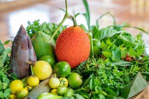 Various local Thai herbs in the basket such as Gac fruit, lime, basil, etc. all of this is an ingredient for healthy cooked food. photo