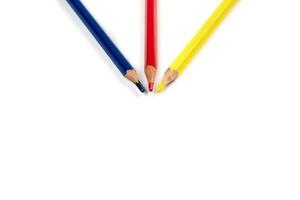 colour pencils 3 primary colours red blue yellow are arranged direction arrow to the center together in studio light. It lay on the white background. Clipping path. photo