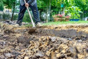 el jardinero cava el suelo con su equipo para jardinería y prepara la tierra para la plantación. foto