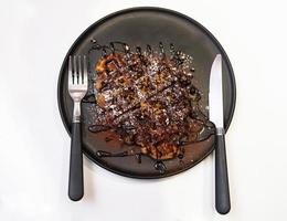 Chocolate waffle in the black dish on the white background. photo