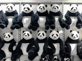 muñecas panda cuelgan de la pared para las ventas en la salida de niños en los grandes almacenes. foto