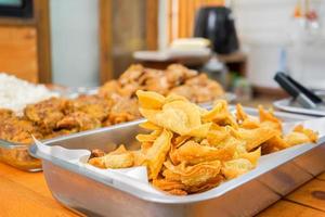 a lot of homemade Thai deep fried wonton in aluminum plate prepare for Asia noodle style. photo